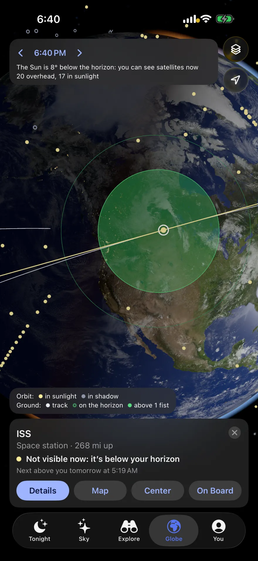 The globe over North America at dusk with the ISS selected: its orbit, the green zone it can be seen from, and a card: “ISS, Space station, 268 mi up. Not visible now: it’s below your horizon. Next above you tomorrow at 5:19 AM.”
