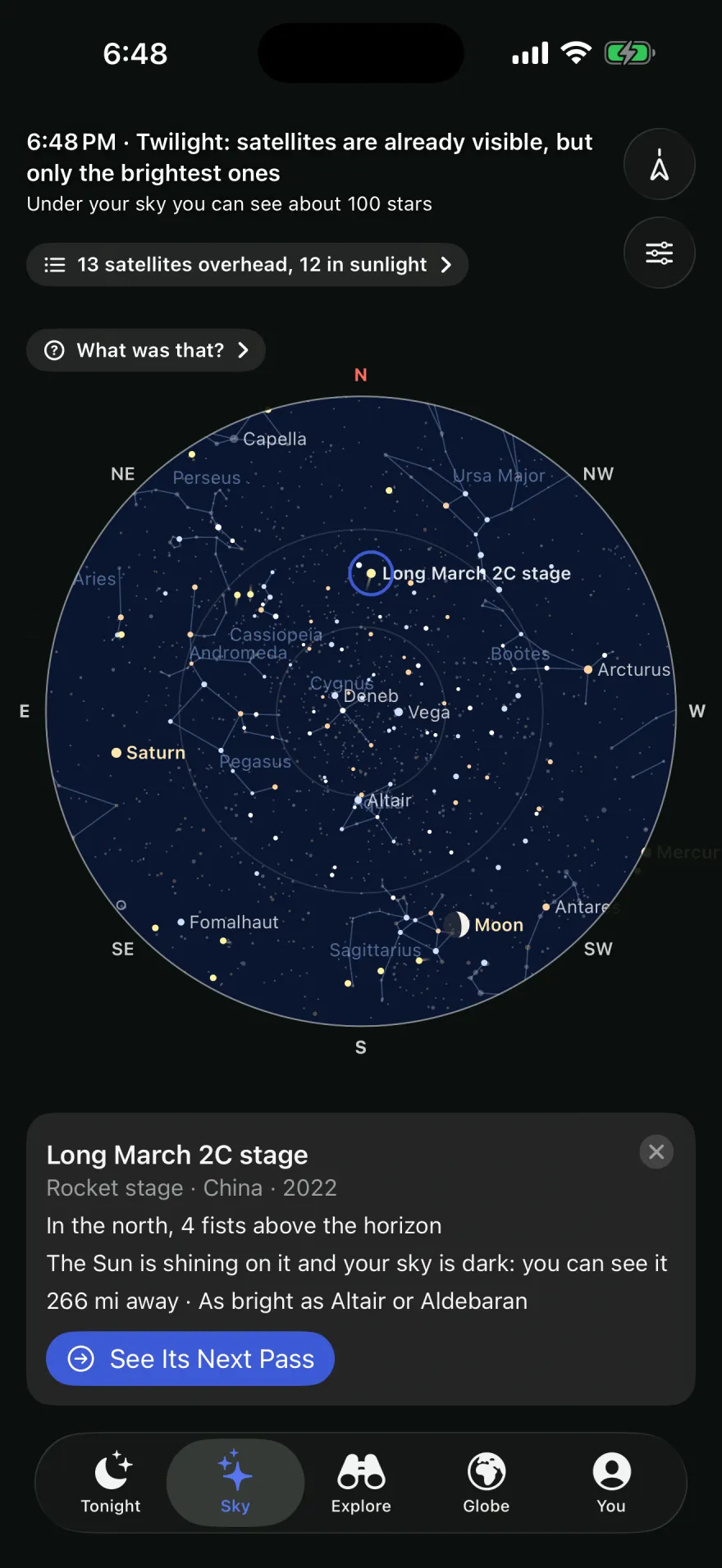 The Sky tab at 6:48 PM: “Twilight: satellites are already visible, but only the brightest ones.” A round star chart with constellations, the Moon and Saturn. Long March 2C stage is selected: in the north, 4 fists above the horizon, the Sun is shining on it and your sky is dark, you can see it.