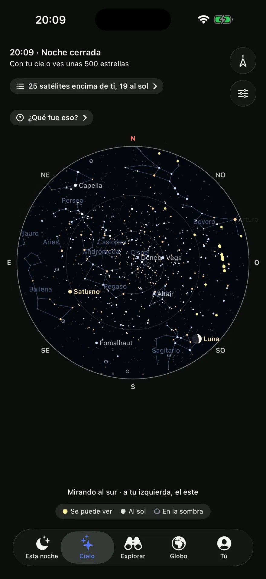 La pestaña Cielo a las 20:09: «Noche cerrada. Con tu cielo ves unas 500 estrellas», «25 satélites encima de ti, 19 al sol» y «¿Qué fue eso?». Un mapa redondo del cielo con las constelaciones, la Luna y Saturno, «Mirando al sur · a tu izquierda, el este». Debajo, la leyenda: se puede ver, al sol, en la sombra.